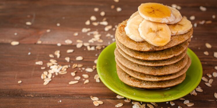 Einige Pancakes sind auf einem grünen Teller übereinander gestapelt.