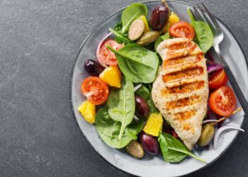 Eine Hühnerbrust ist auf einem Salat-Bett angerichtet.