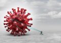 Grafik: Ein Mann zieht ein riesiges Coronavirus hinter sich her.