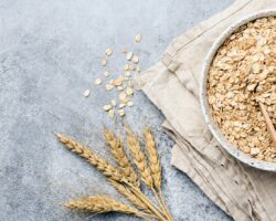 Eine Schüssel voll Haferflocken steht auf einer hellblauen Oberfläche.