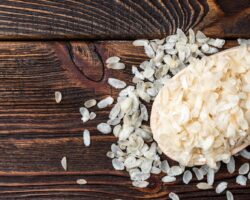Reisflocken auf einem großen Holzlöffel.