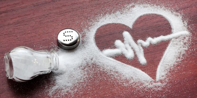 Verstreutes Salz auf einem Tisch bildet eine Herz-Form.