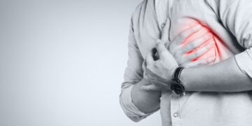 Mann fasst sich an die Brust beziehungsweise das Herz.