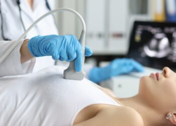 Eine Ärztin führt bei einer Patientin eine Ultraschallbehandlung durch.