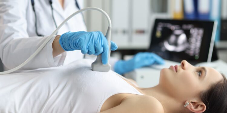 Eine Ärztin führt bei einer Patientin eine Ultraschallbehandlung durch.