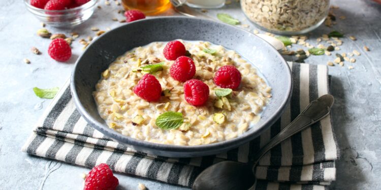 Eine Portion Haferflocken mit Himbeeren garniert.