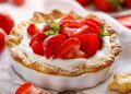 Eine Tarte mit Erdbeeren und Frischkäse, serviert in einer weißen Auflaufform.