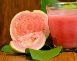 Guaven-Frucht und ein Glas mit Guavensaft in Großaufnahme.